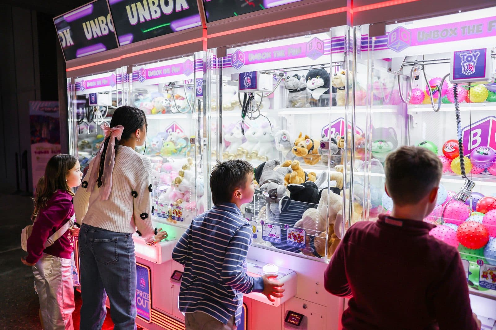 Kids trying the claw machines in the arcade